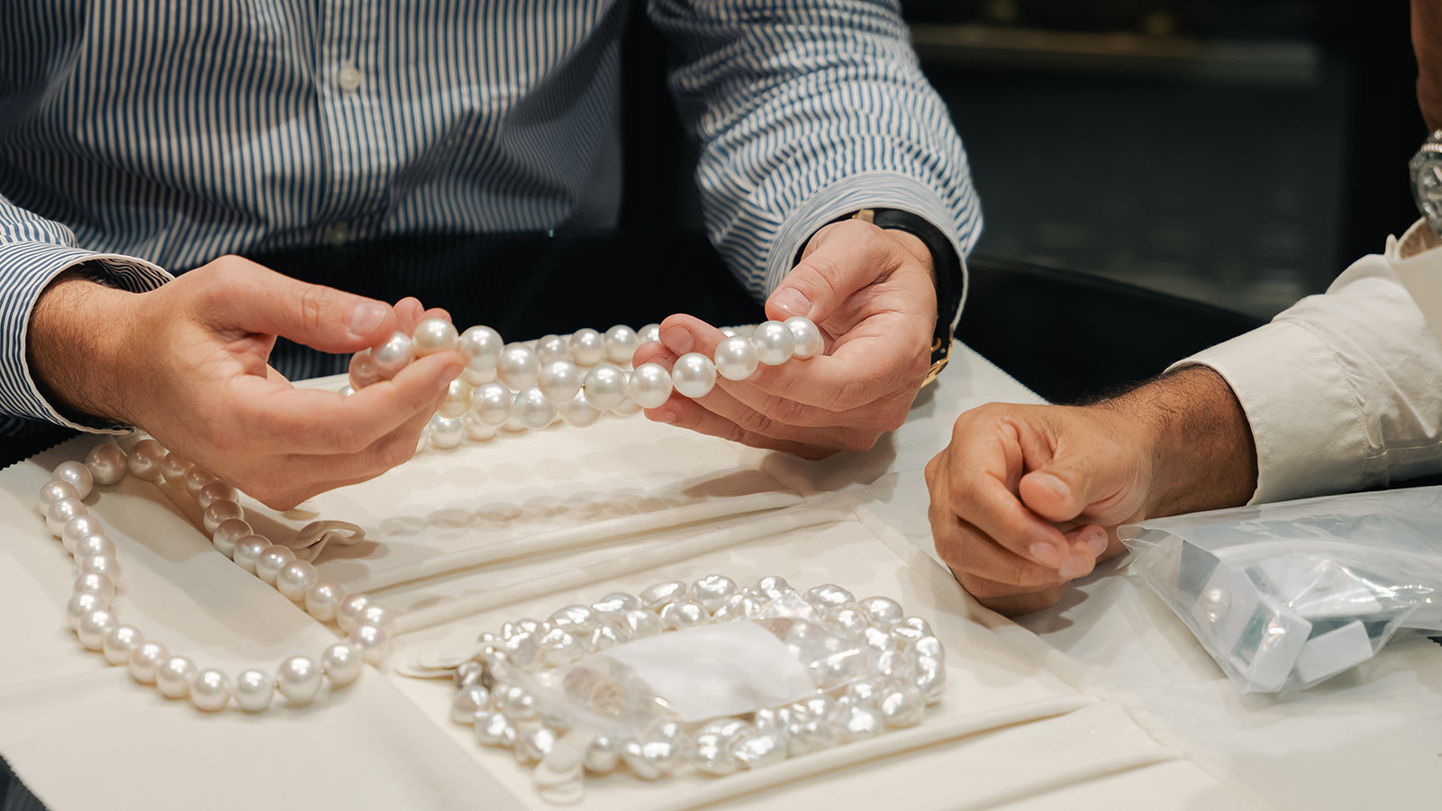 large Australian south sea pearl strands being examined.