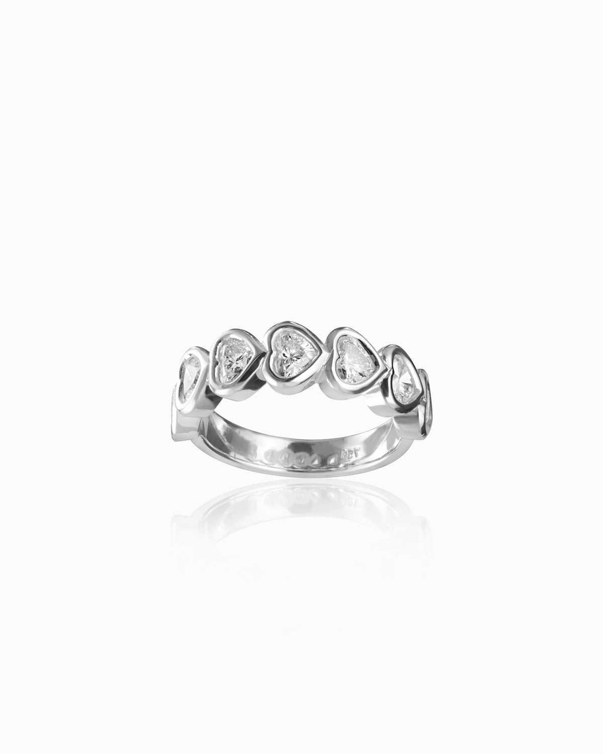 Elegant 18k white gold band featuring seven heart-shaped diamonds in bezel settings, each diamond with a G color and VS clarity, arranged in a symmetrical pattern to enhance their brilliance and sparkle.