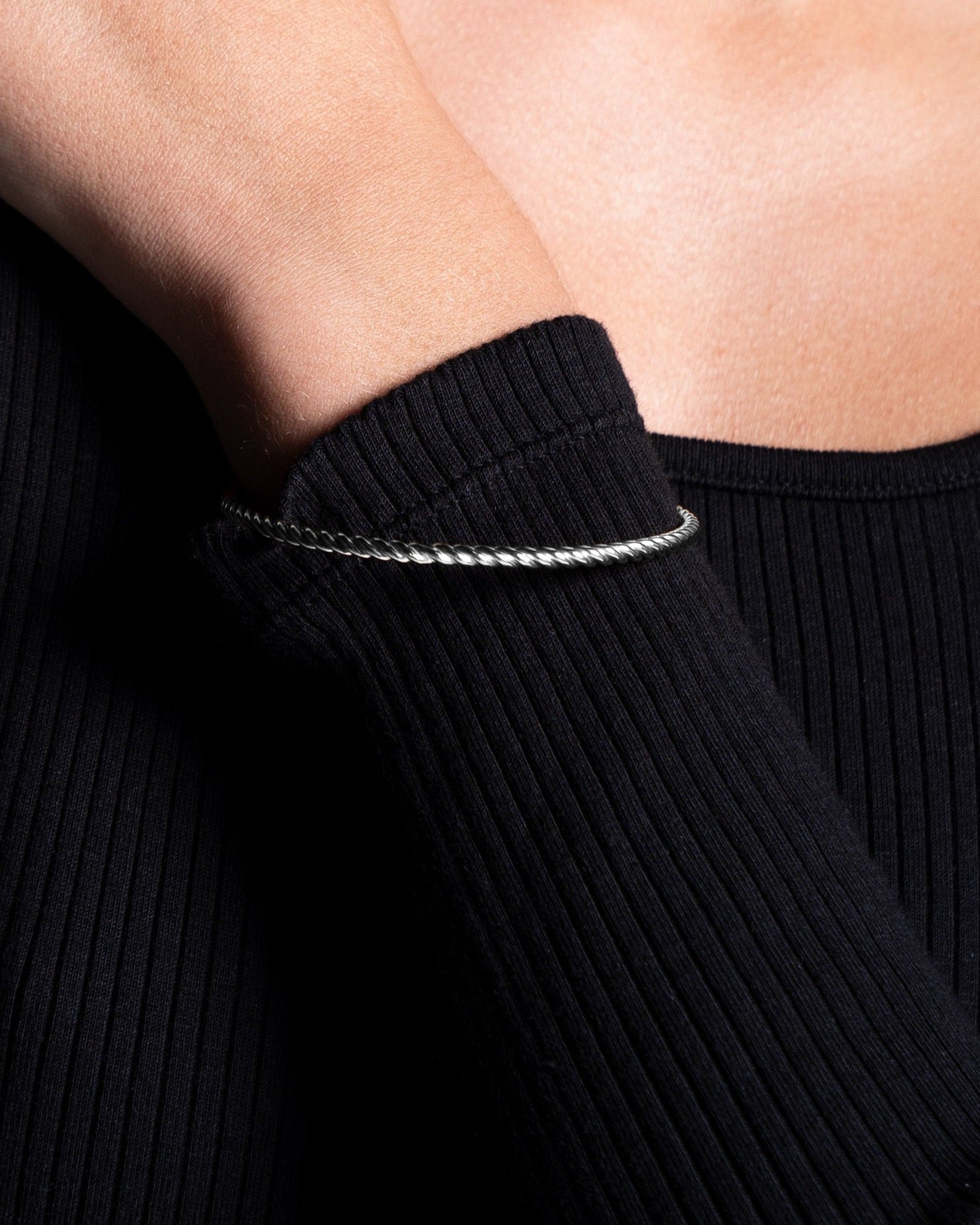 9 karat solid white gold twisted bangle on model close up image