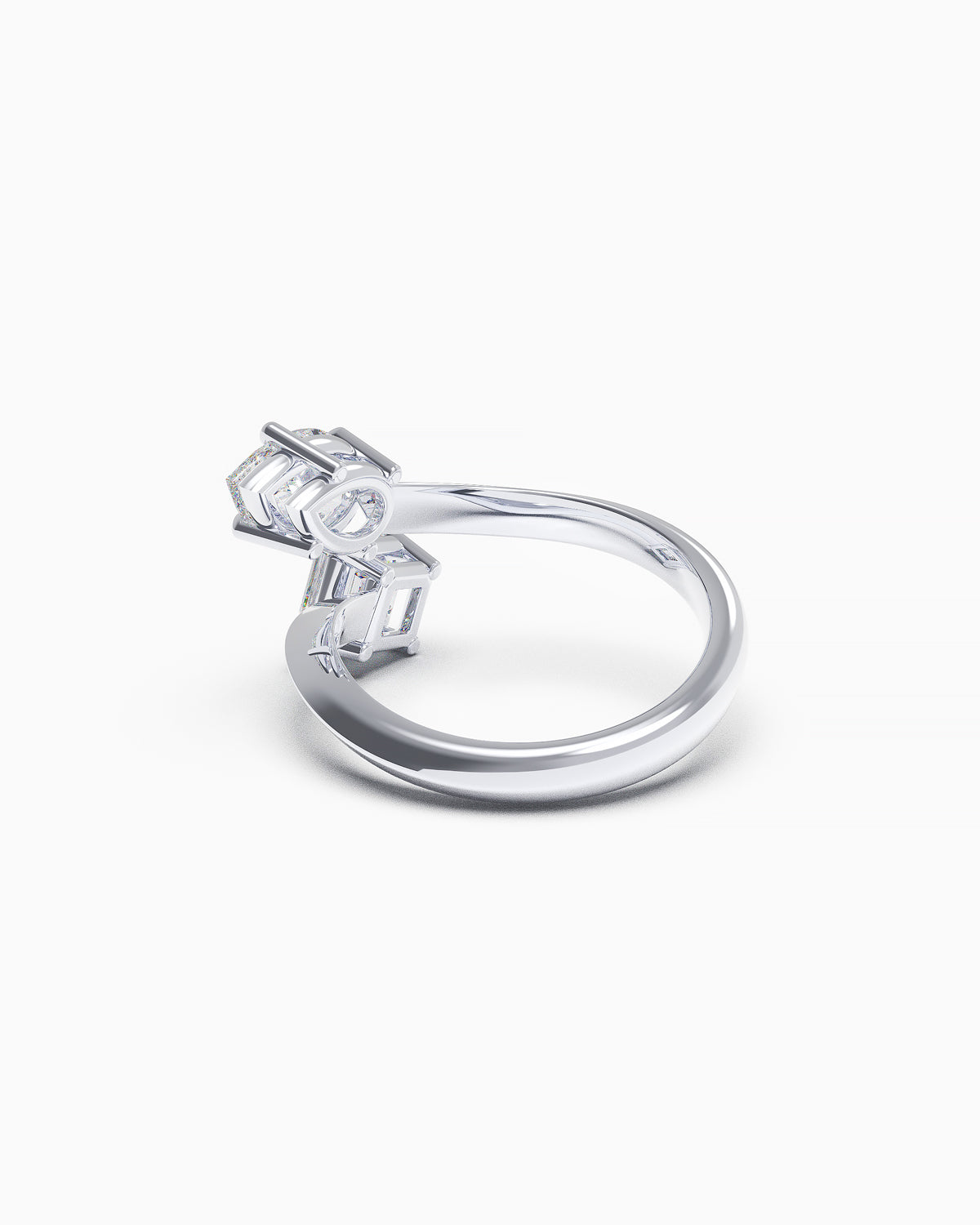 Rear view of a bypass ring in 18k white gold, showing pear and Asscher-cut diamond settings with sculptural open shank.