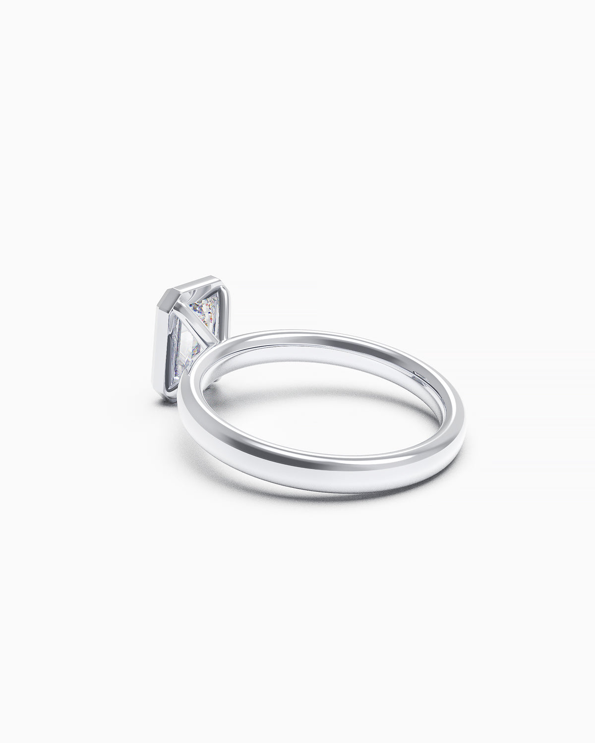 side view of a white gold or platinum engagement ring with a vertically set emerald-cut diamond in a bezel setting, photographed on a white background.