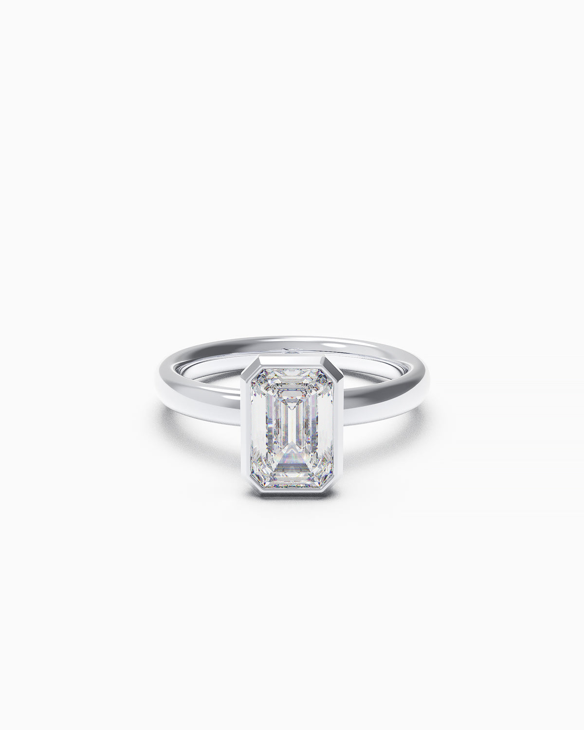 A white gold or platinum engagement ring with a vertically set emerald-cut diamond in a bezel setting, photographed on a white background.