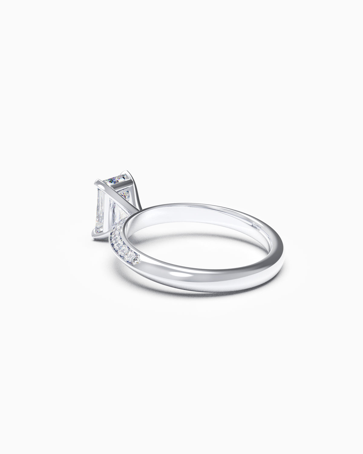 Side profile of an emerald-cut diamond ring featuring a pavé knife-edge band, showing the taper and height of the claw setting.