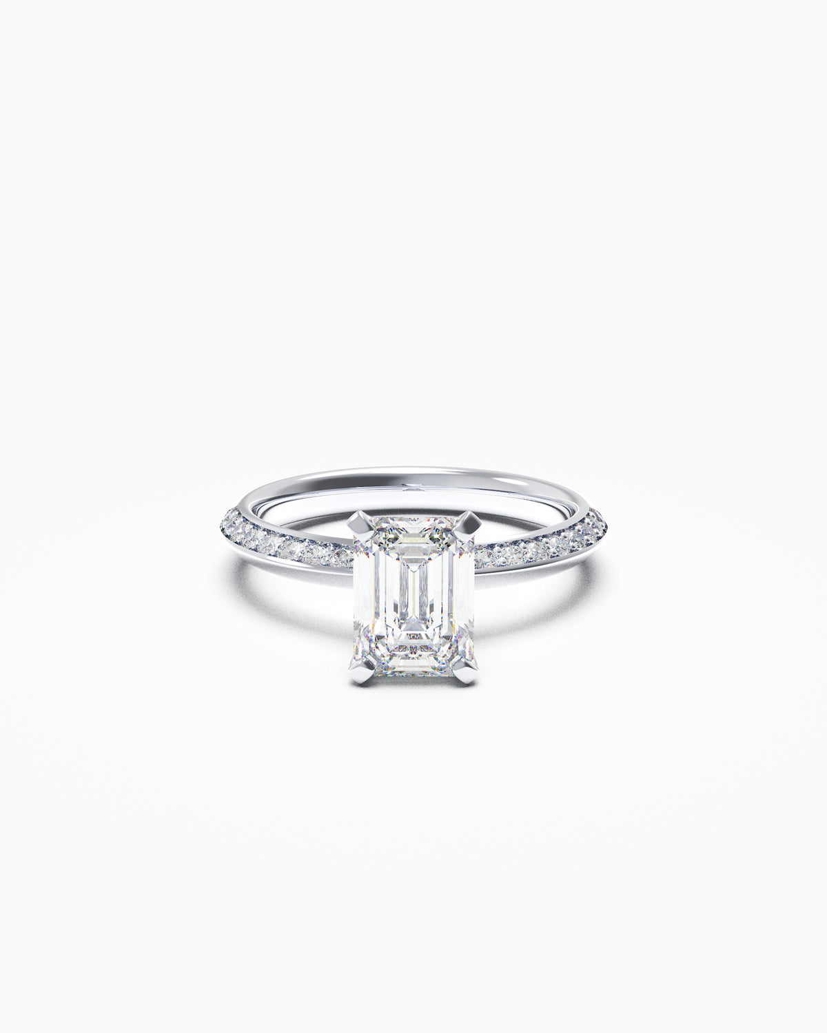 Emerald-cut diamond engagement ring with pavé knife-edge band in yellow or white gold, front view on white background.