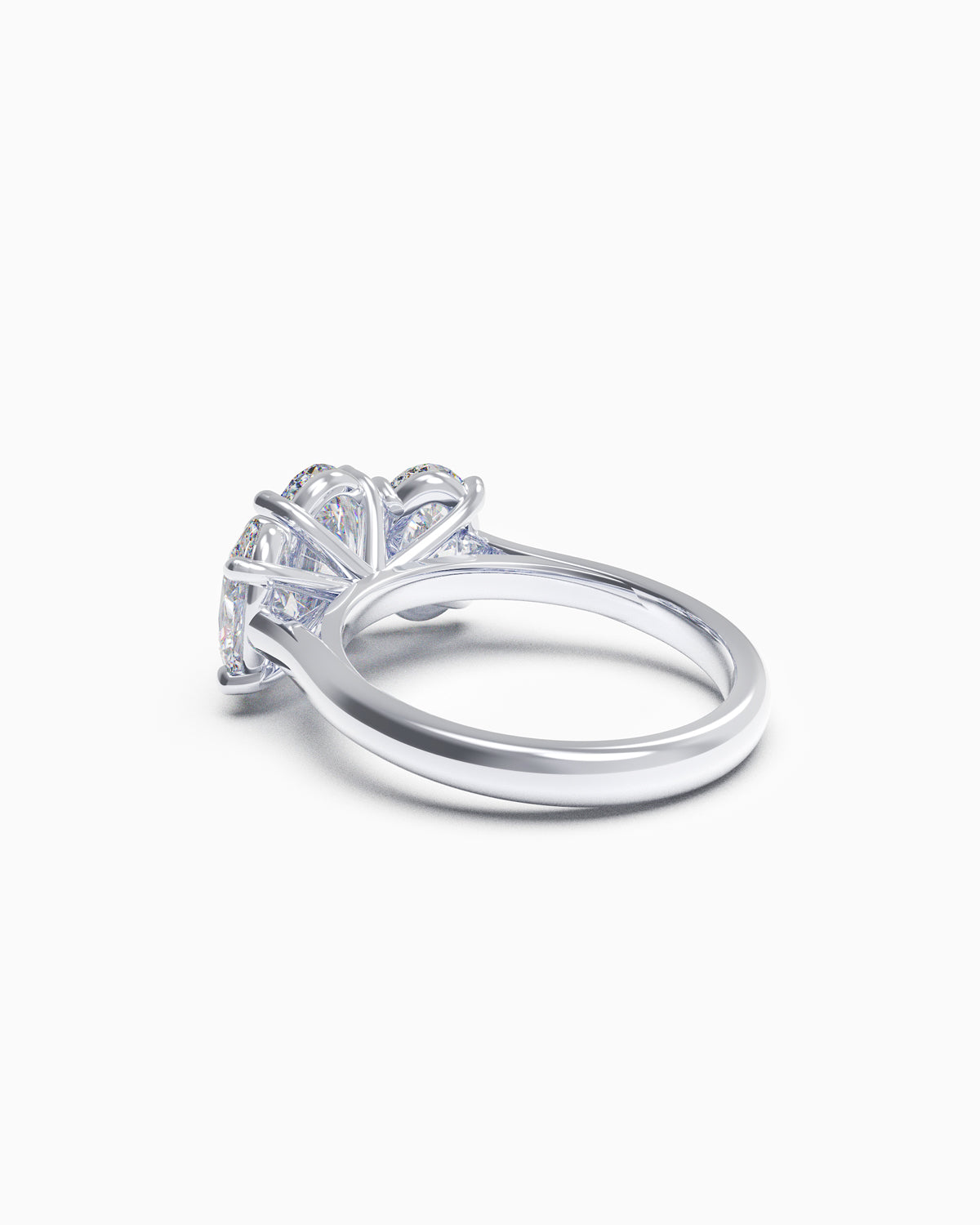 Side view of an oval trilogy diamond ring with claw settings, highlighting the low-profile design and customisable 18k gold band.