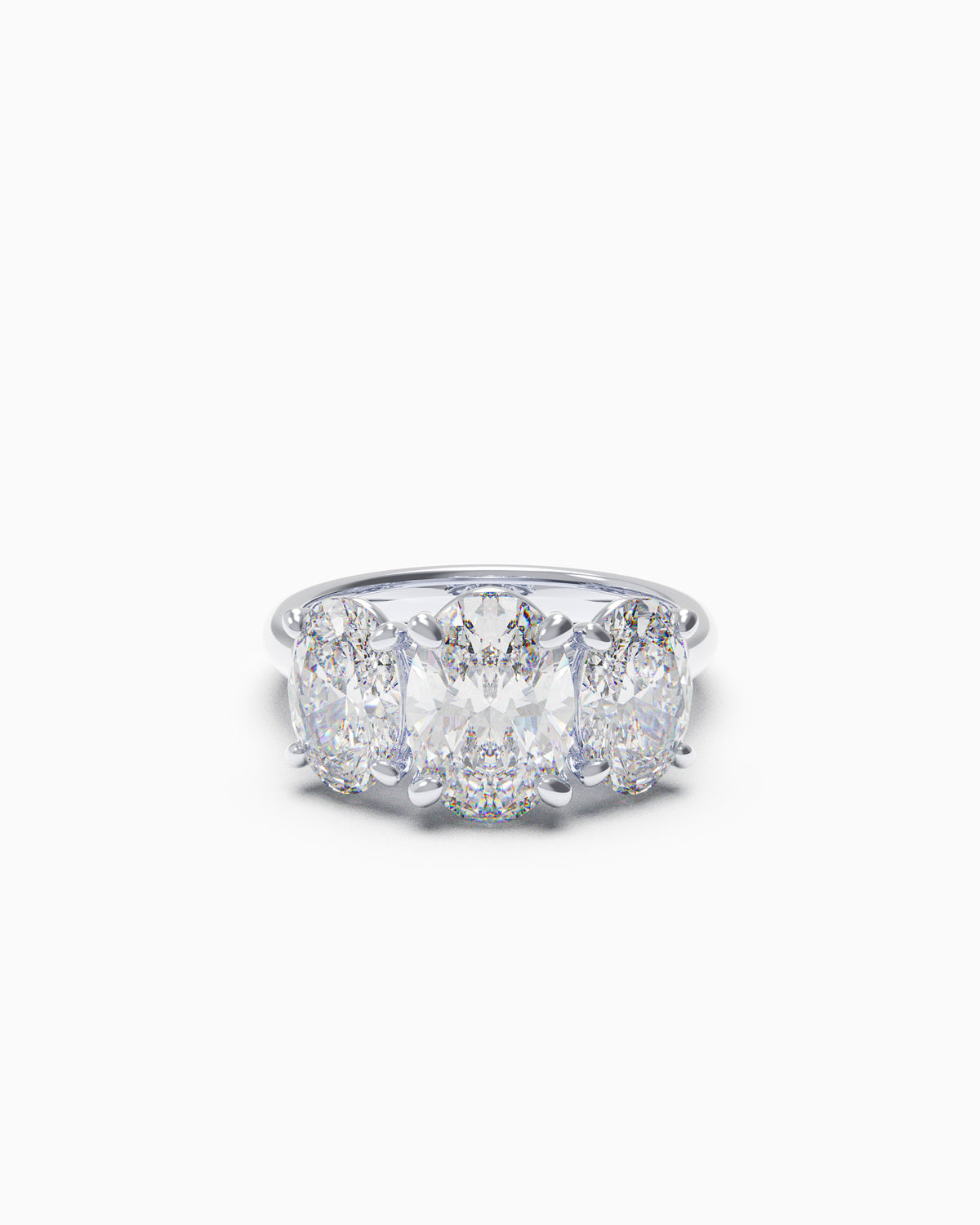 Trilogy engagement ring with three oval-cut diamonds and a slim band, shown in yellow and white gold, available in any 18k metal.
