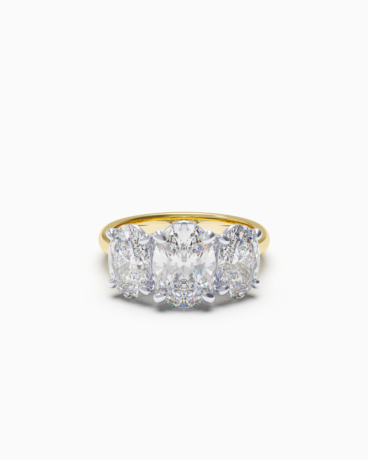 Trilogy engagement ring with three oval-cut diamonds and a slim band, shown in yellow and white gold, available in any 18k metal.