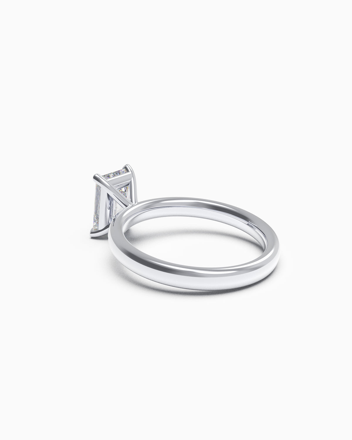 side view of a radiant-cut diamond solitaire engagement ring in a four-claw setting, available in yellow or white gold, photographed on a white background.