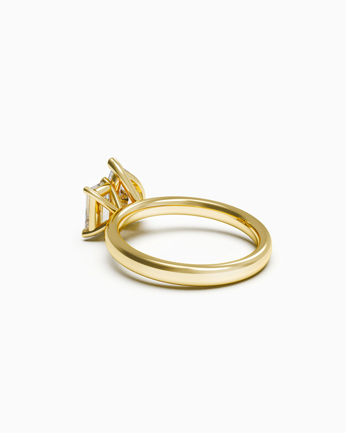 A two-stone engagement ring featuring a pear-cut and an emerald-cut diamond, set in yellow gold. side view