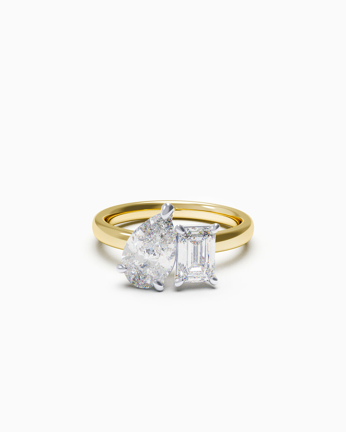 A two-stone engagement ring featuring a pear-cut and an emerald-cut diamond, set in yellow and white gold
