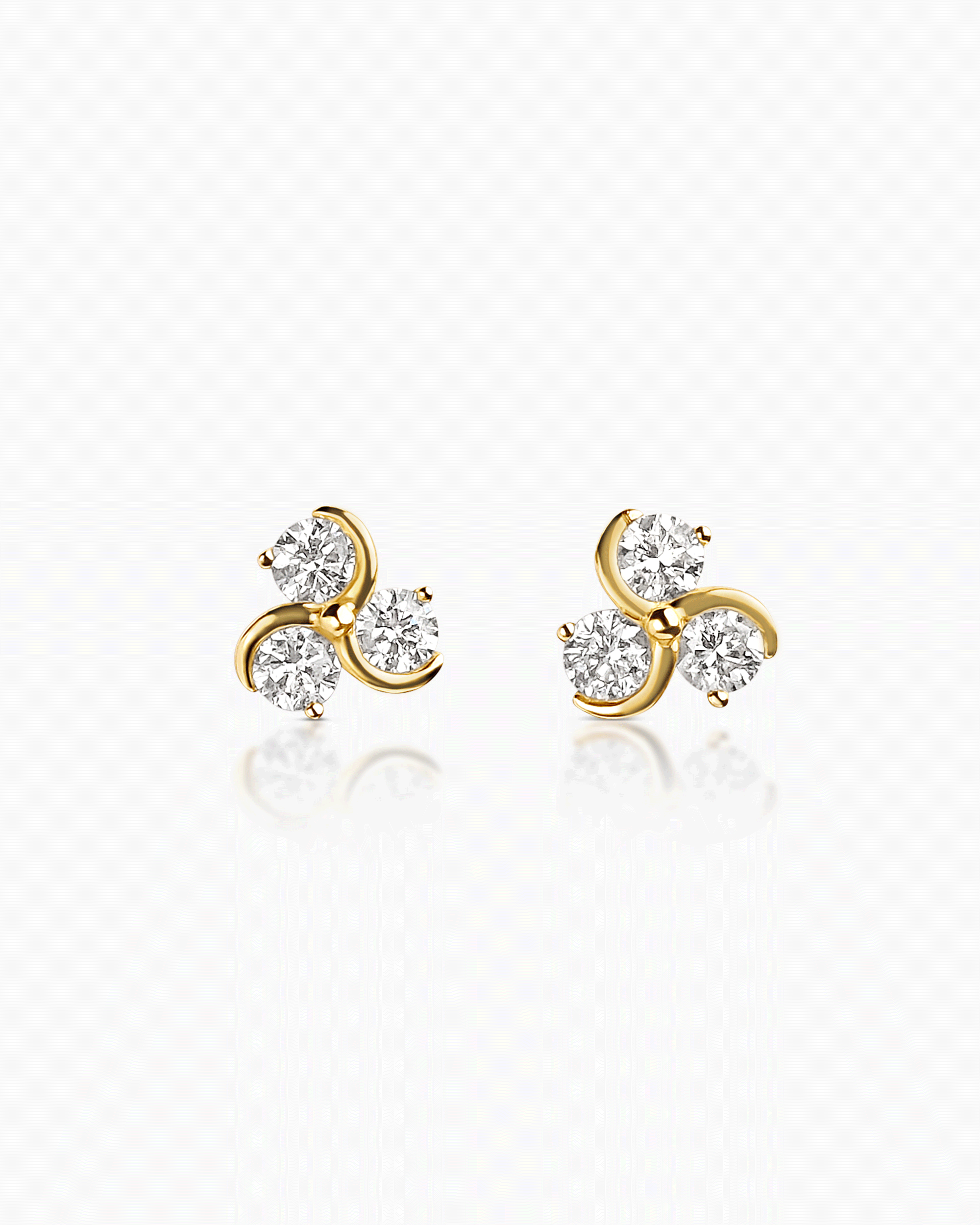 Gold stud earrings with three round diamonds arranged in a triangular cluster, set in curved 18k yellow gold prongs.