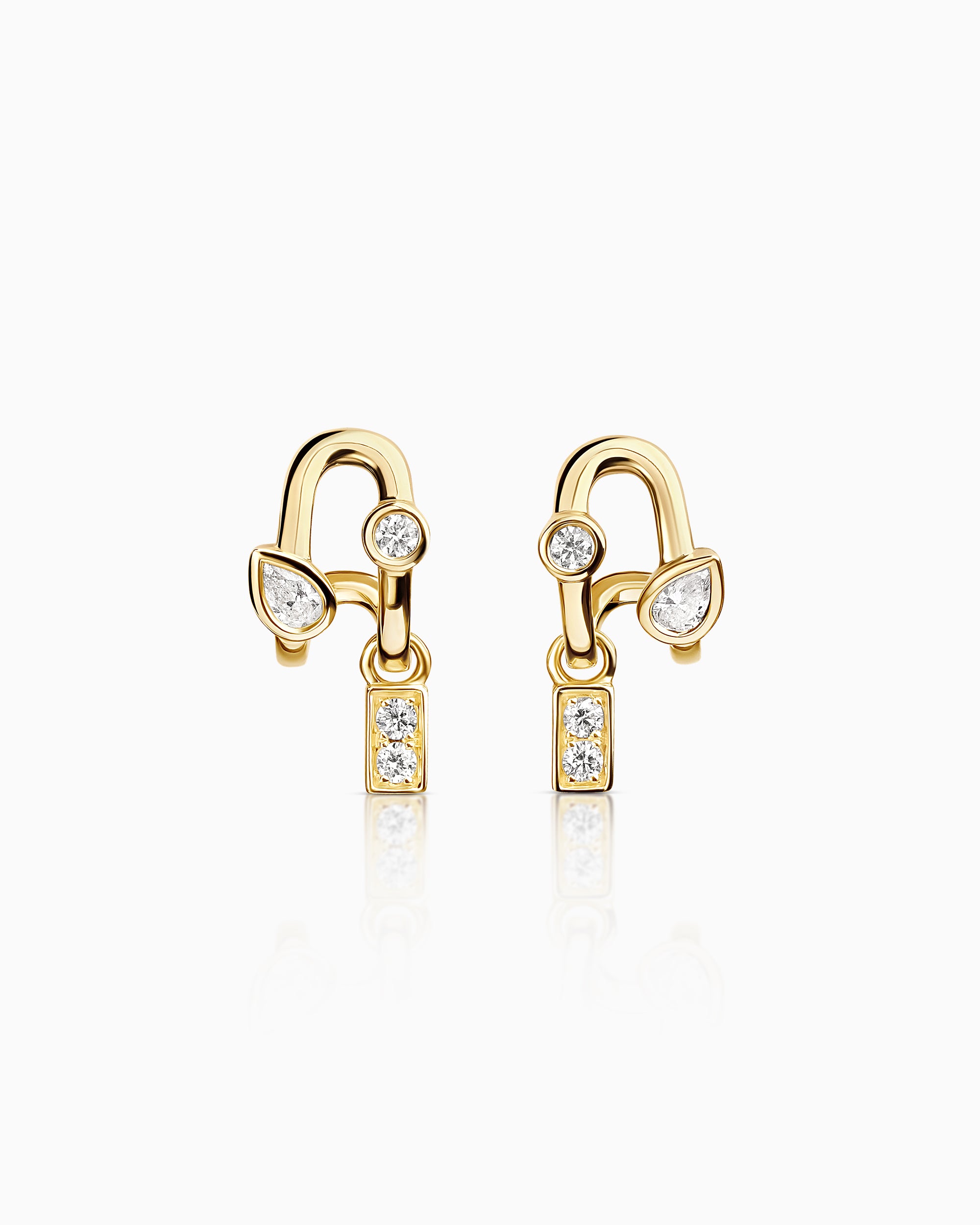 Gold earrings with clear gemstones on a white background