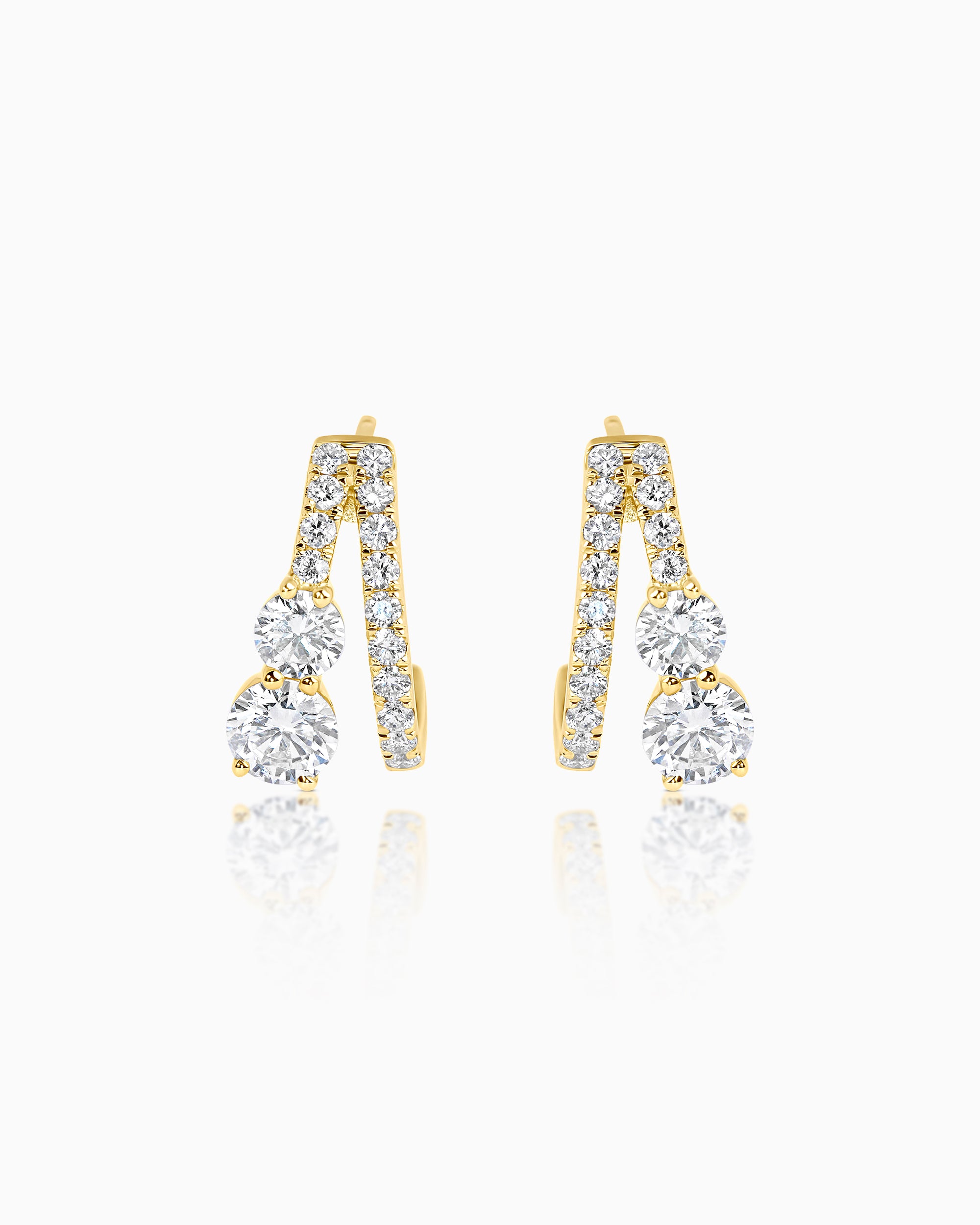 18k yellow gold split earrings with two scallop-set round brilliant diamond arms diverging from a single post, each ending at a claw-set round brilliant diamond, photographed as a pair on a light grey background