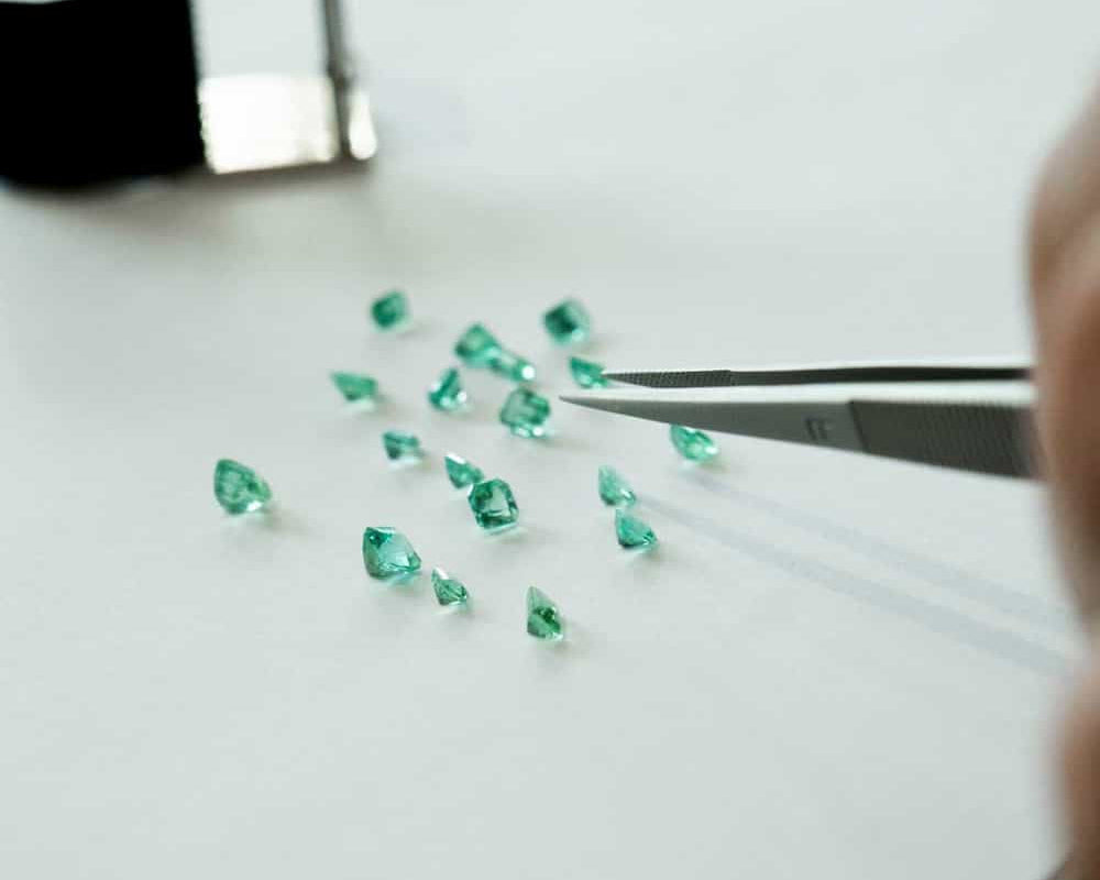 Emerald gemstone parcel being sorted by jeweller from claude and me jewellery