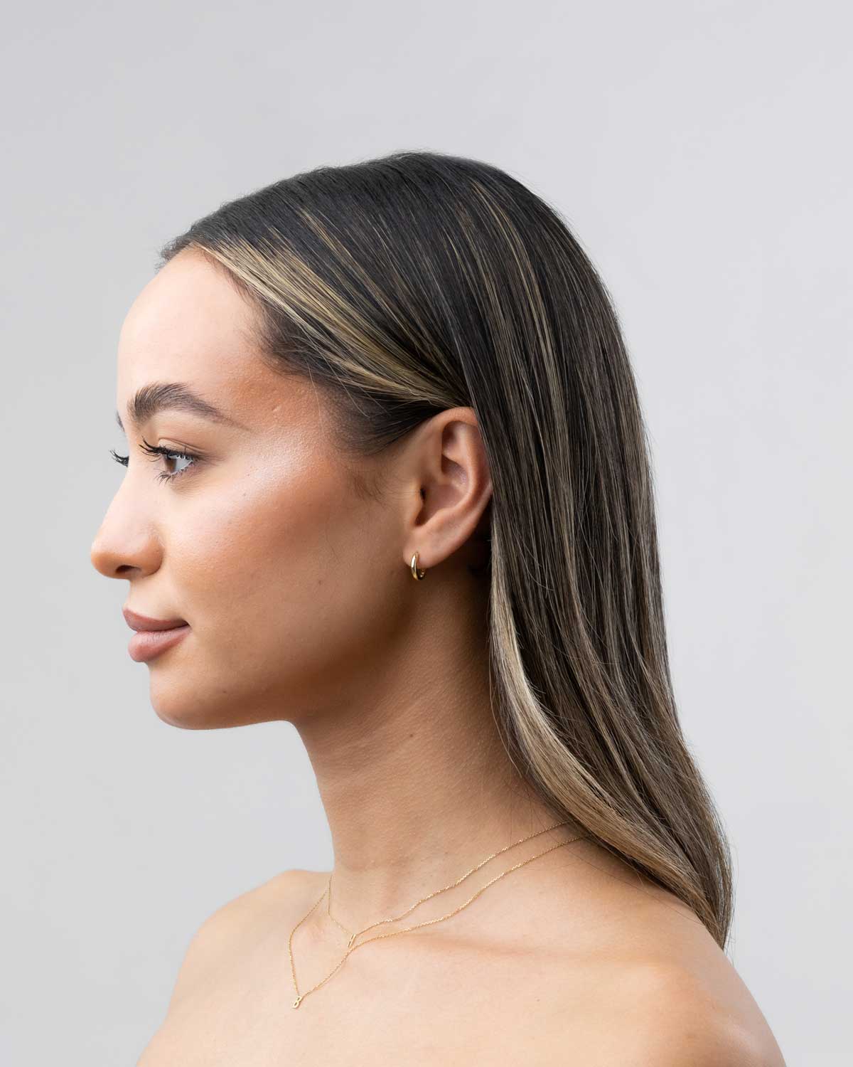 18 karat yellow gold mini huggies claude by claudia on model