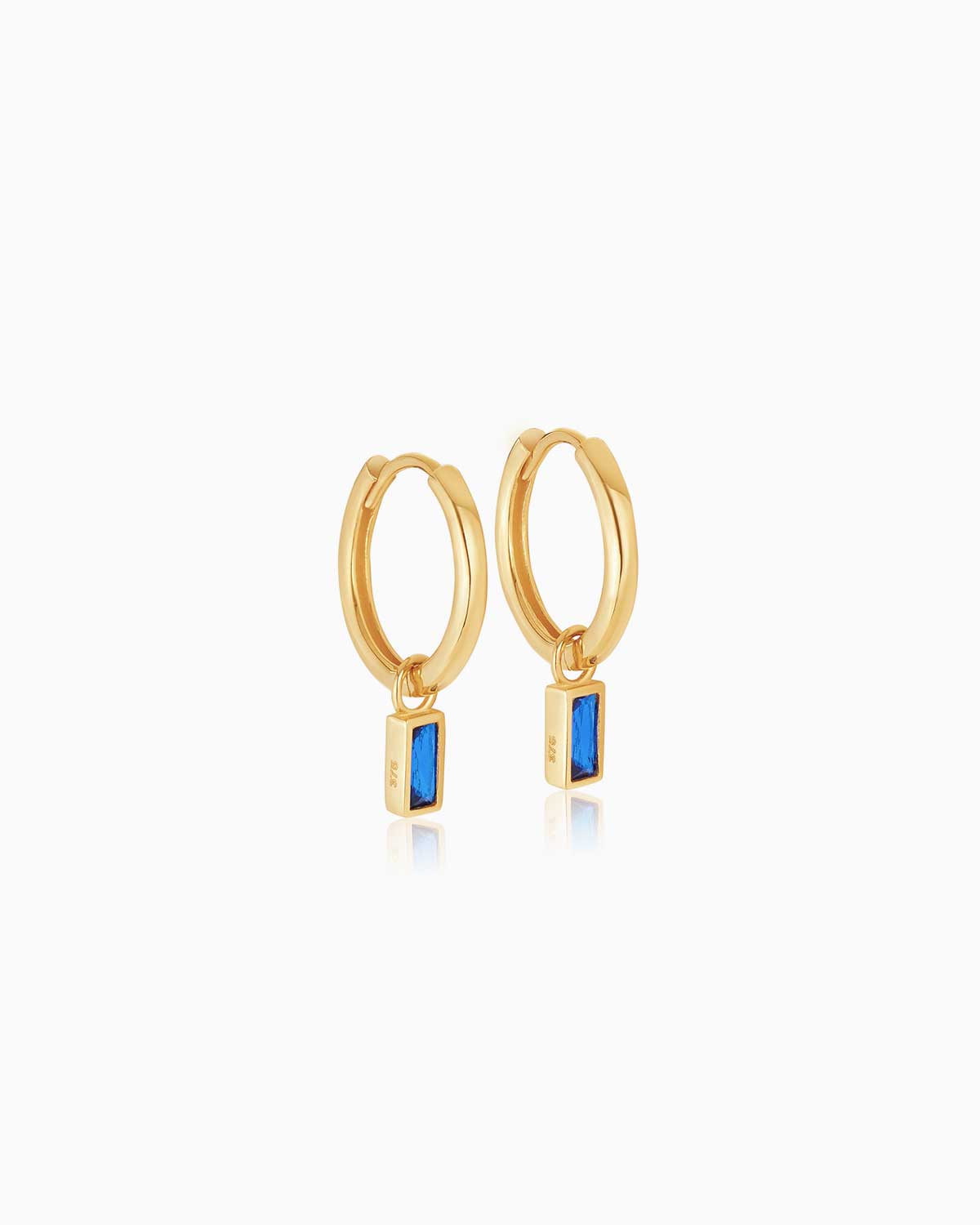 9 karat yellow gold charm hoop earrings with sapphire bezel set drops from the claude by Claudia collection.