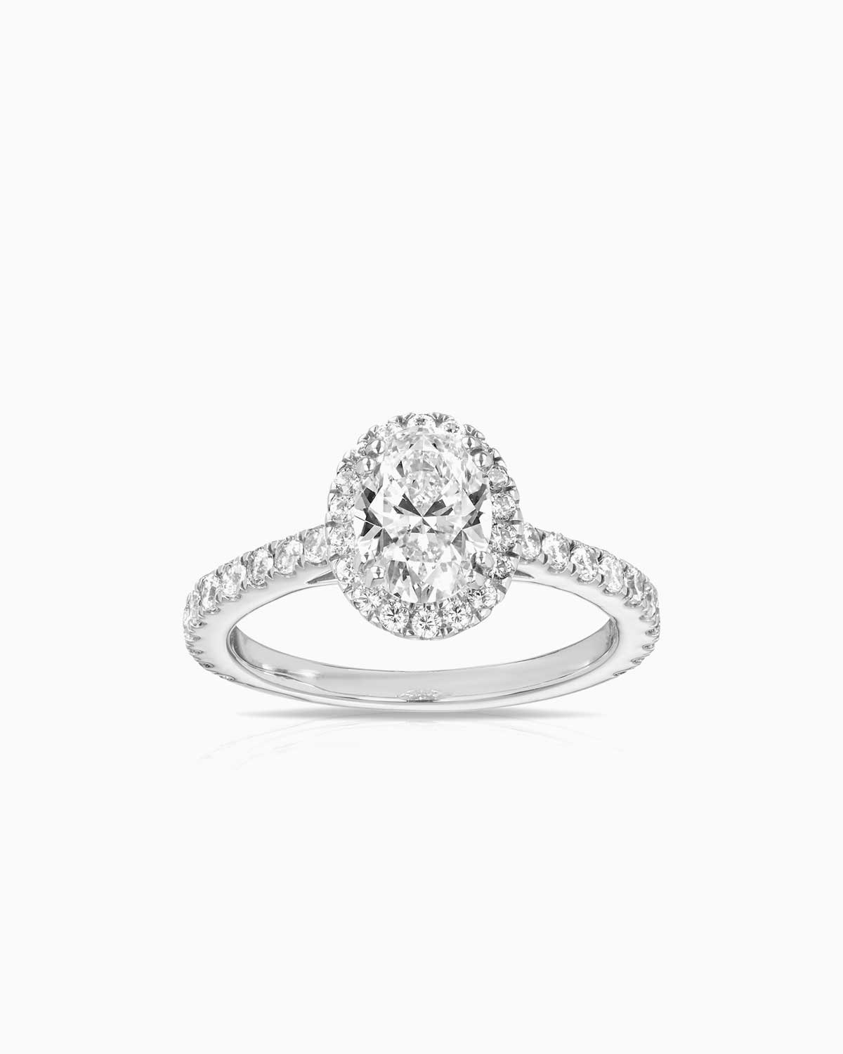 oval halo diamond engagement ring featuring shoulder diamonds and set in 18 karat white gold by claude and me jewellery
