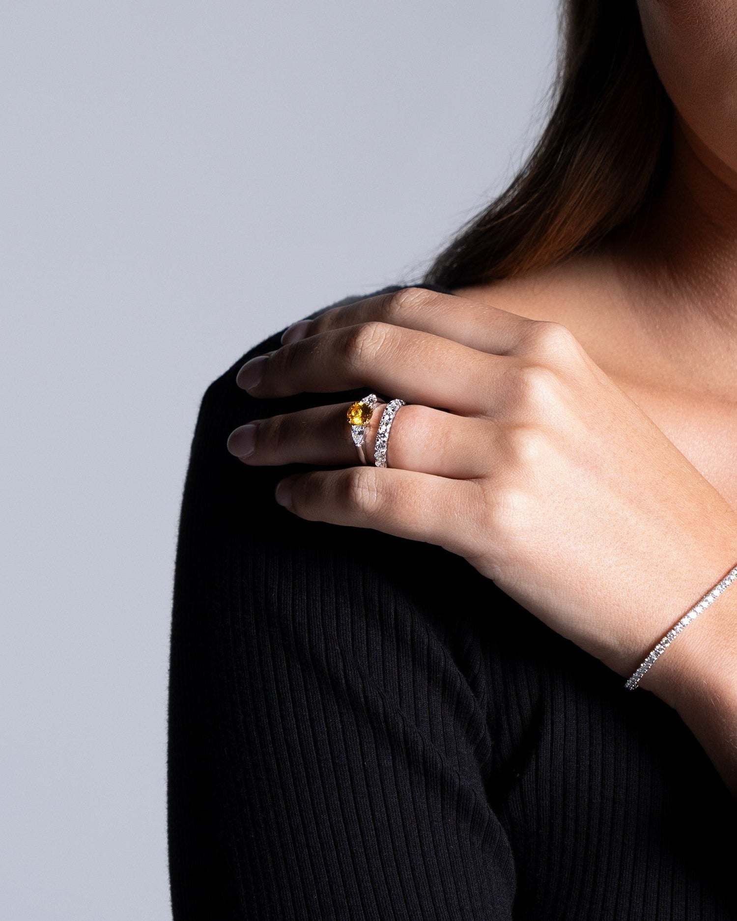 orange sapphire trilogy and diamond band from claude and me jewellery worn on models hand Ellie Brinkman