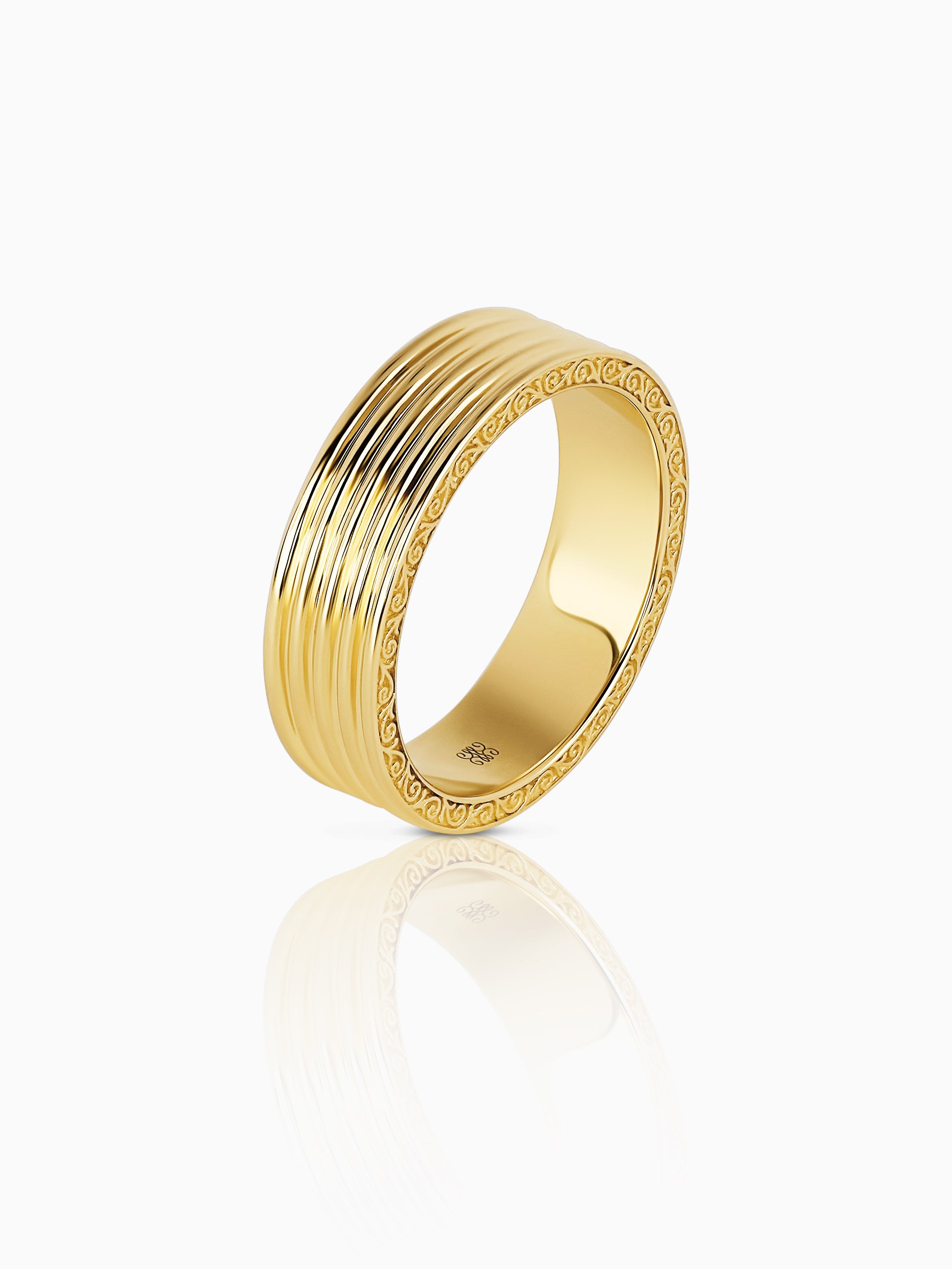 Wide yellow gold band with a finely reeded face and engraved scrolling borders along both edges, photographed against a white background.