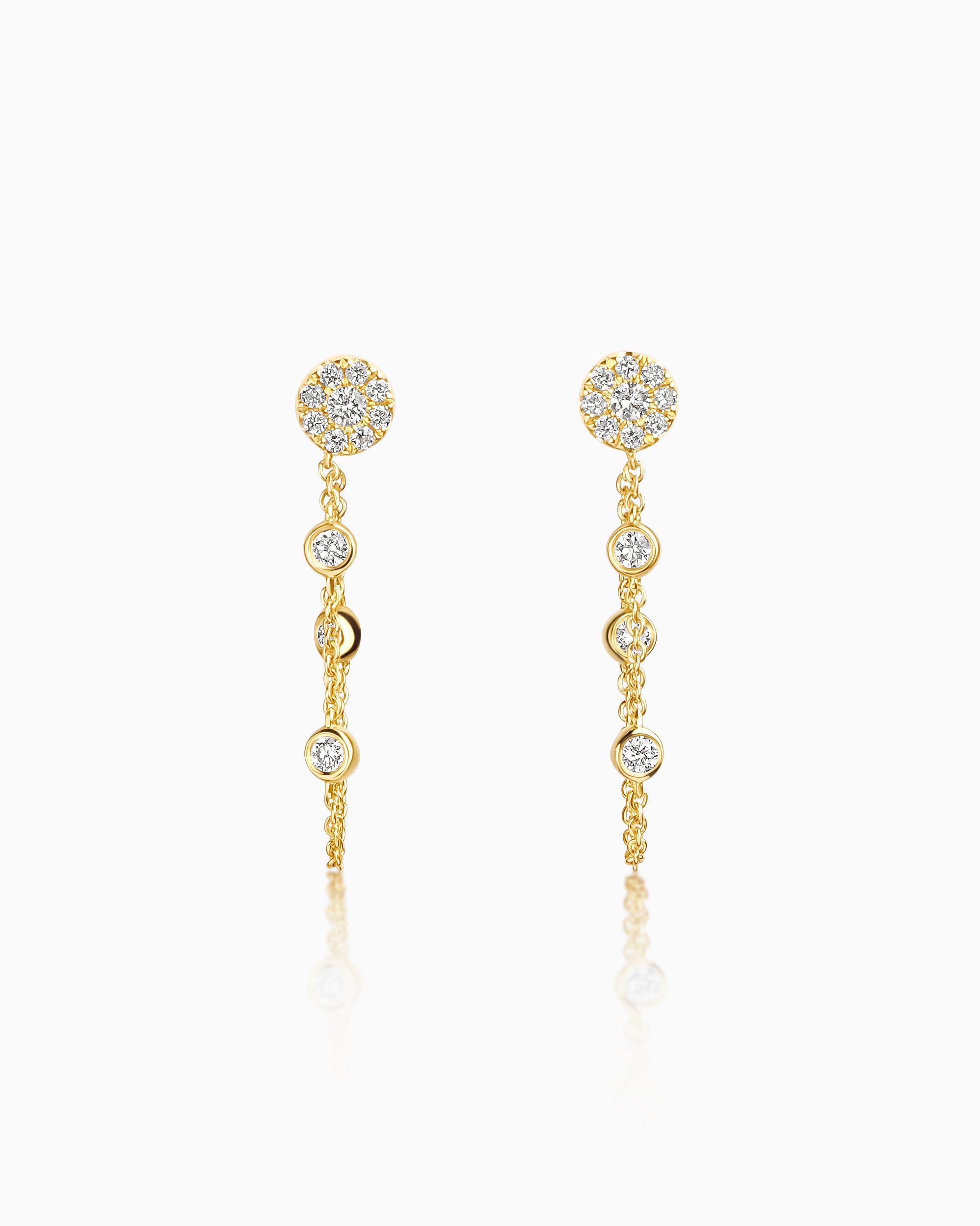 Pair of 18k yellow gold drop earrings with a diamond cluster stud and three bezel-set diamonds suspended on fine chain.