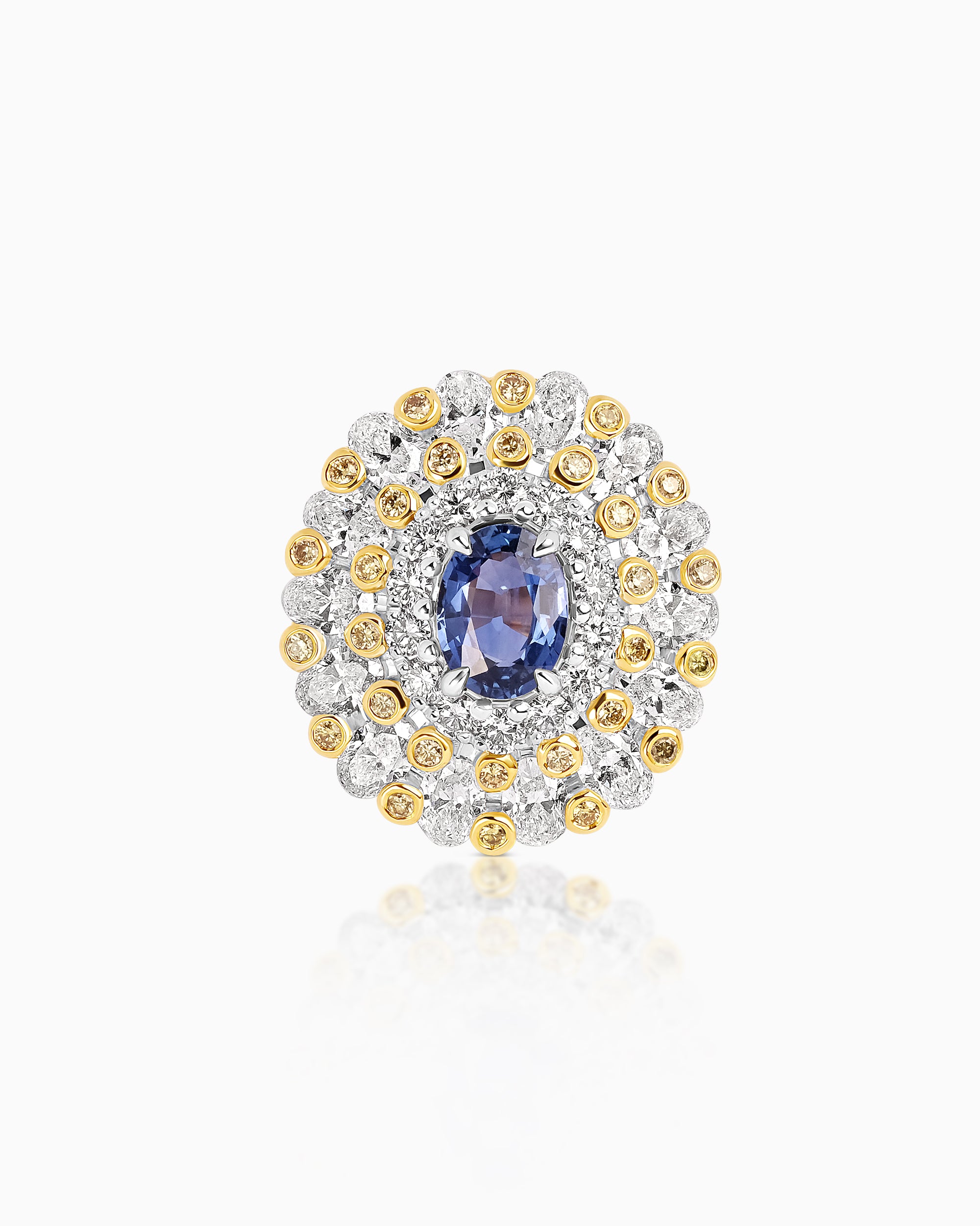Statement ring featuring an oval sapphire centre stone surrounded by concentric halos of white and yellow diamonds set in 18k gold.
