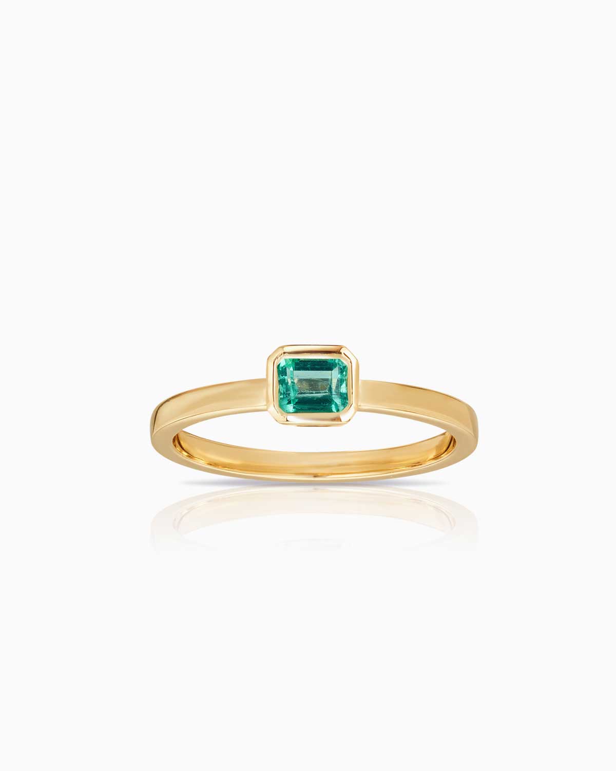 bezel set colombian emerald ring in 9 karat yellow gold