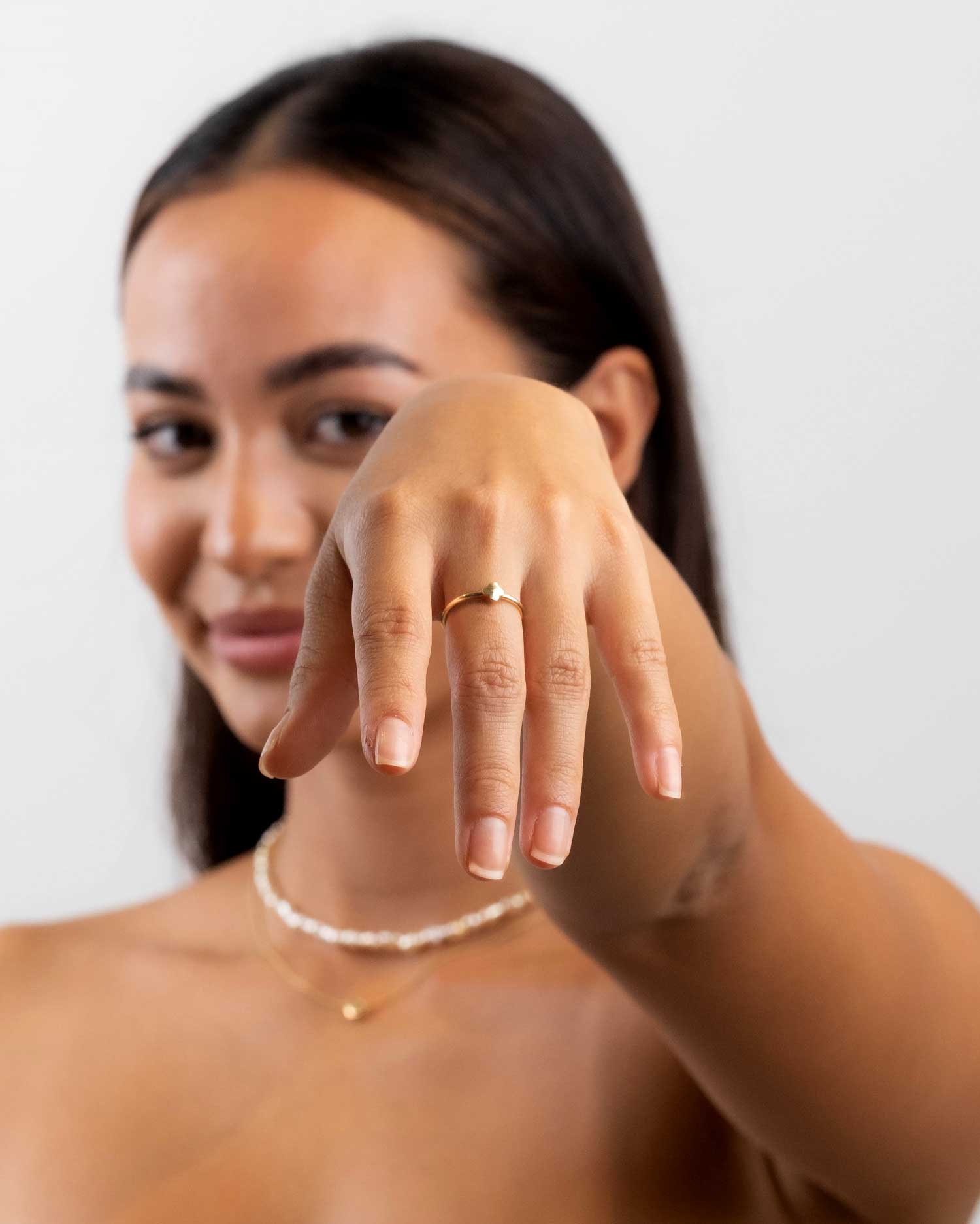 hannah meek showing off the 9 karat yellow gold fine trefle ring from the claude and me jewellery collection