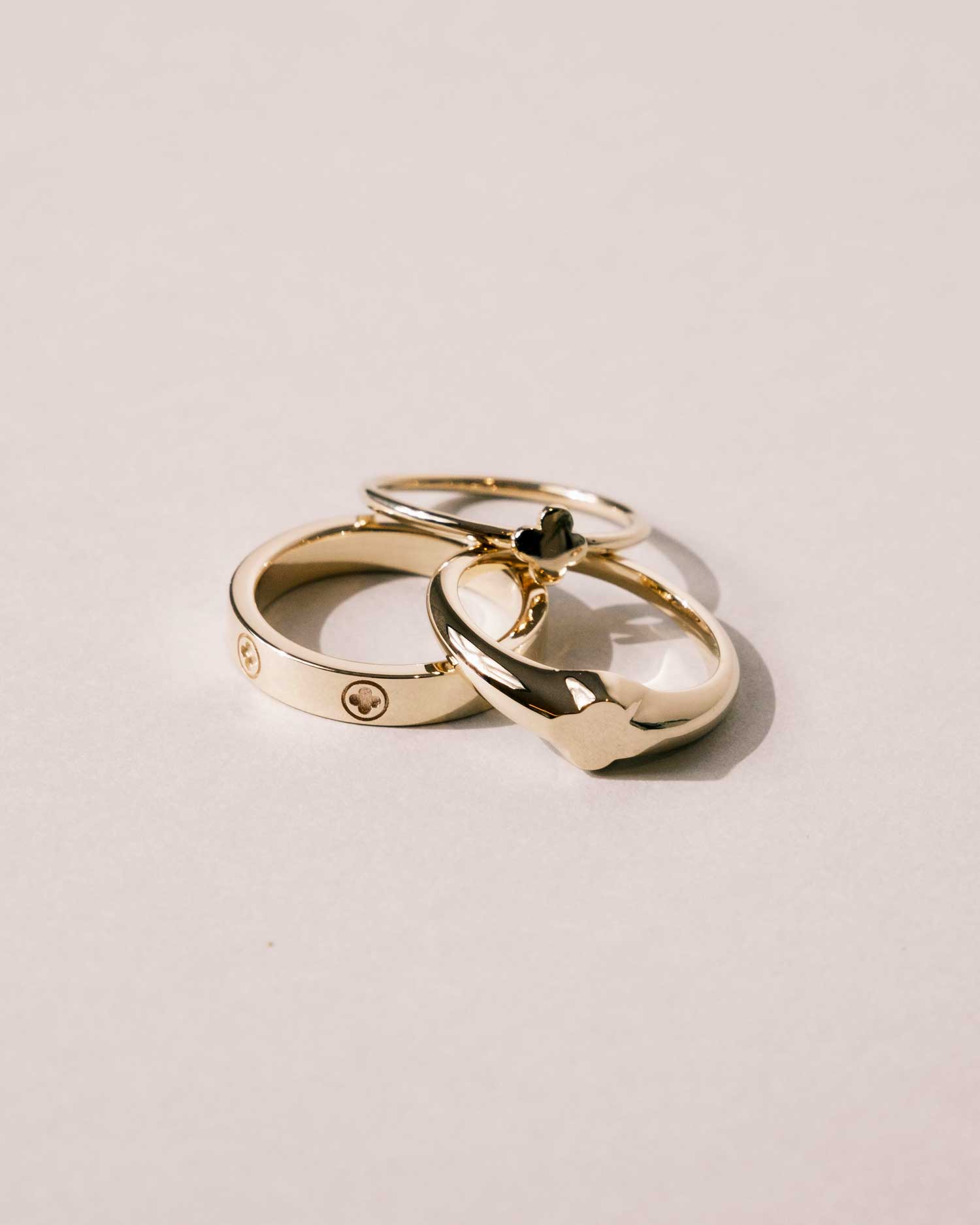 trèfle collection of rings from claude and me jewellery stack on a white surface